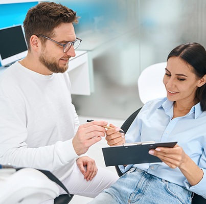 Patient in Oklahoma City filling out forms for teeth whitening